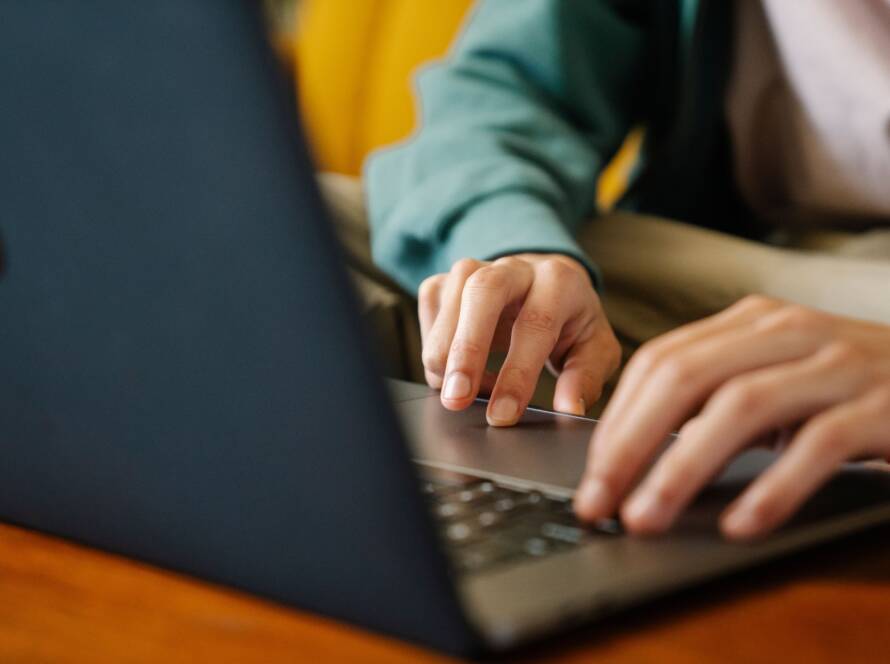 Hands typing on a laptop