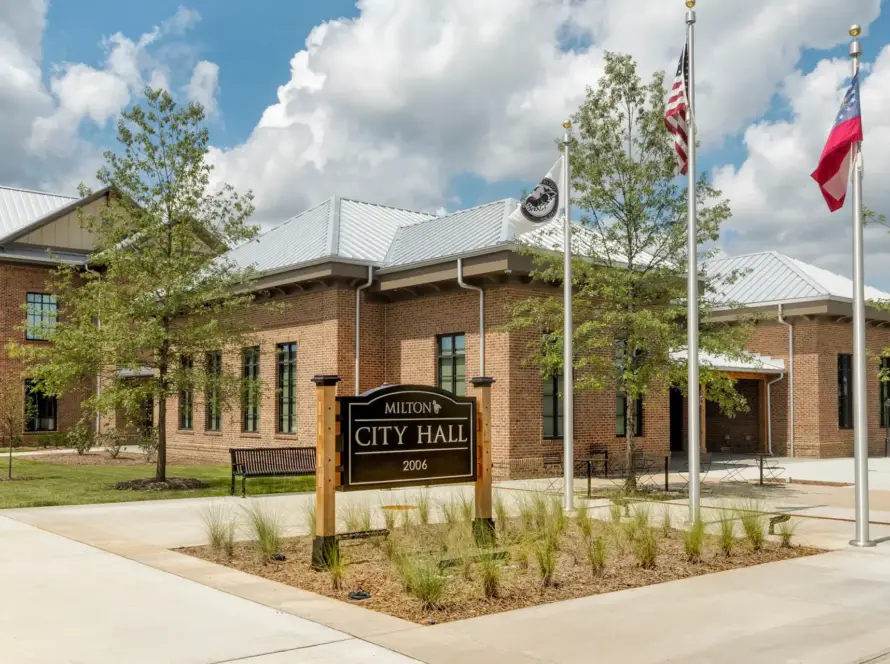 Exterior of the new Milton City Hall with flags and City Hall sign