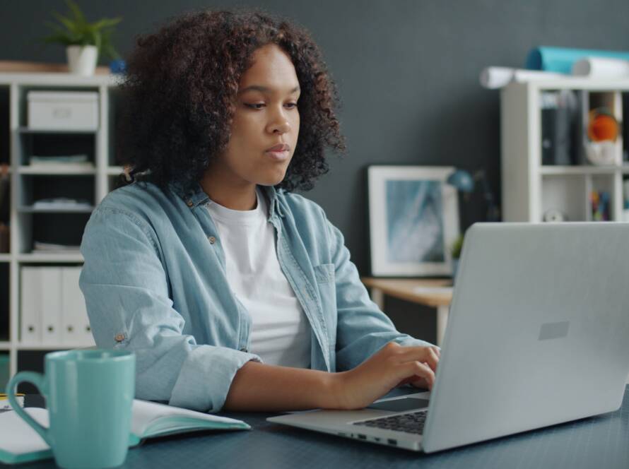 Woman working from home on a laptop at a desk in a home office