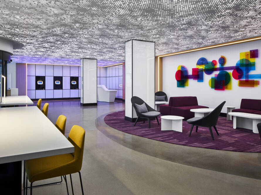 Lobby of YOTEL Washington DC with lounge seating, colorful wall art and self check-in kiosks
