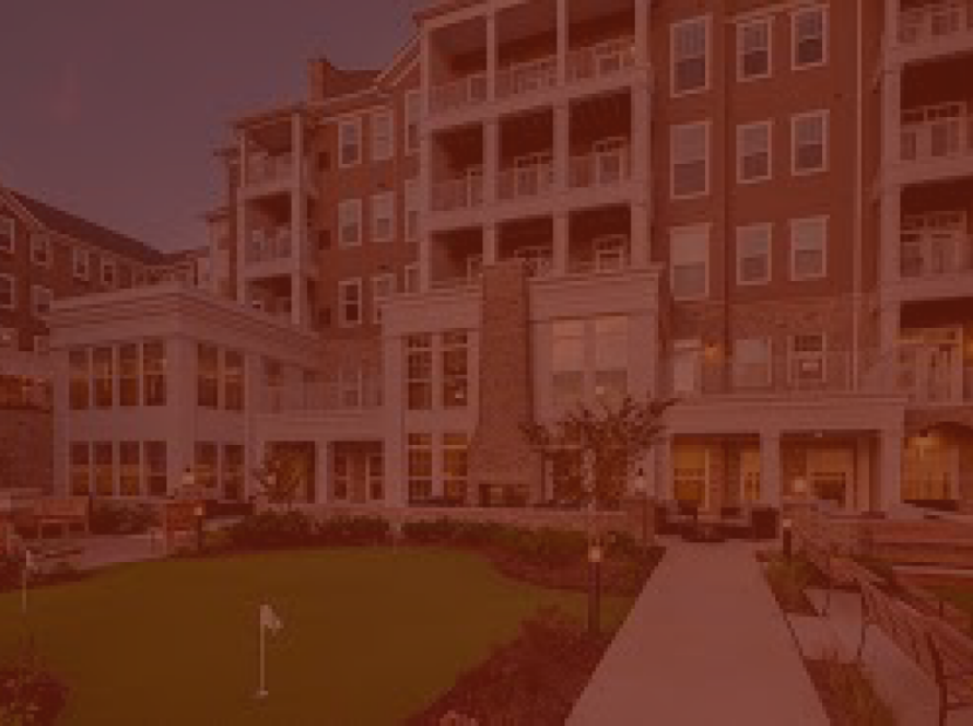 Senior living community building and courtyard with putting green, under a red color overlay
