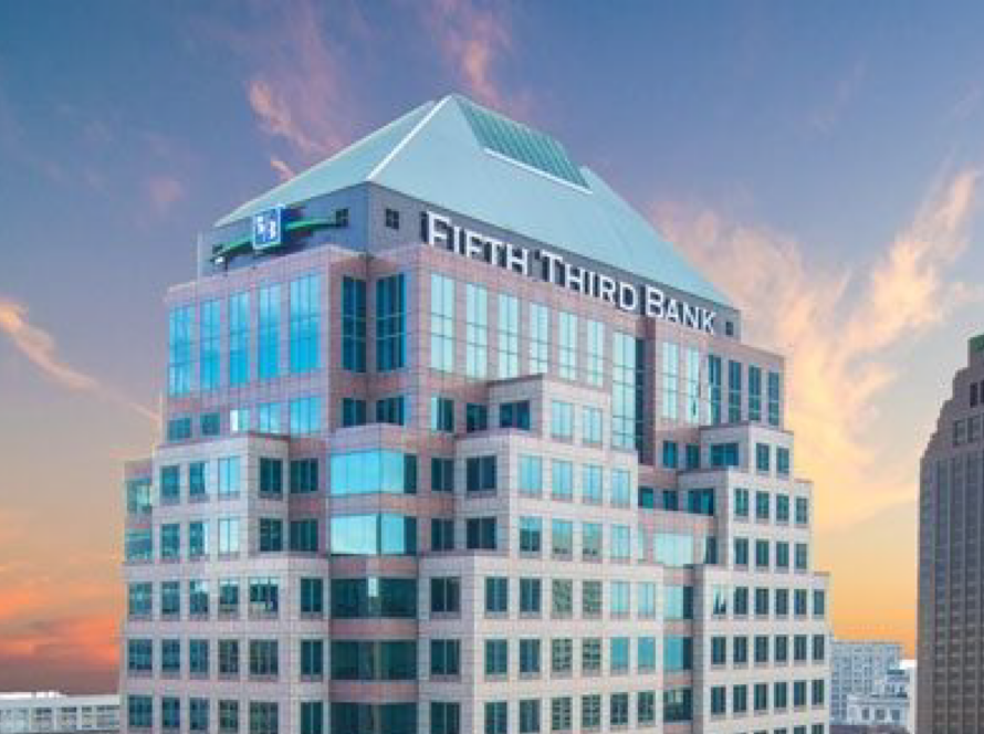 Fifth Third Bank office tower with its name at the top against a sunset sky
