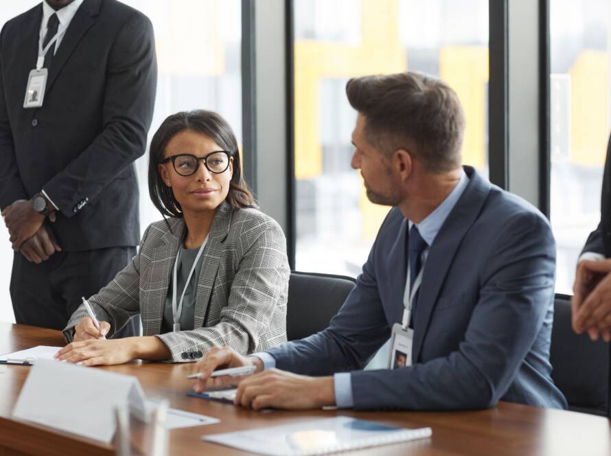 Business professionals with ID badges in a meeting at a conference table