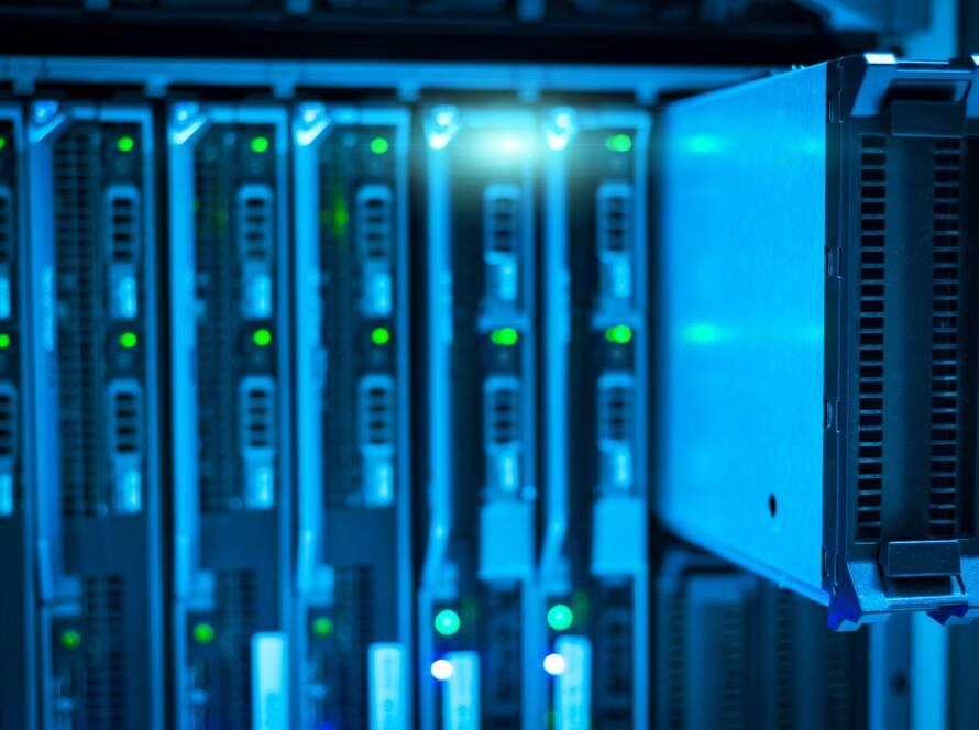 Close-up of blade servers in a data center rack lit in blue