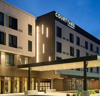 Entrance and porte-cochère of a Courtyard by Marriott hotel at dusk