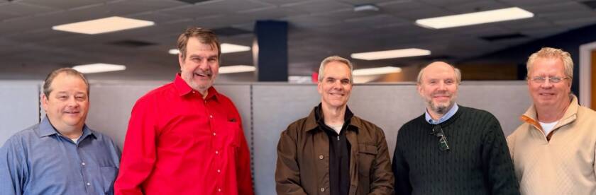 Five members of the NTI leadership team standing together in an office
