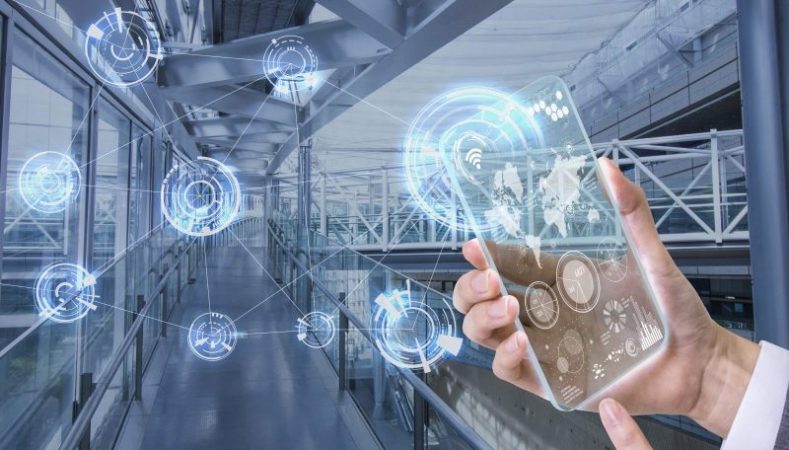 Hand holding a transparent smartphone with digital network icons over a modern walkway