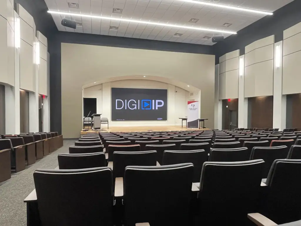Aldridge Auditorium seating facing a stage with a DIGI IP display