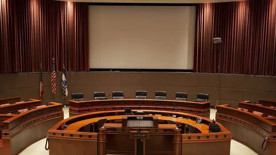 Fulton County Board of Commissioners Assembly Hall with curved dais, flags and projection screen