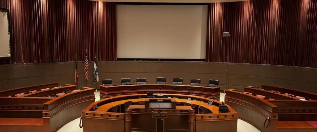 Fulton County Board of Commissioners Assembly Hall with curved dais, flags and projection screen