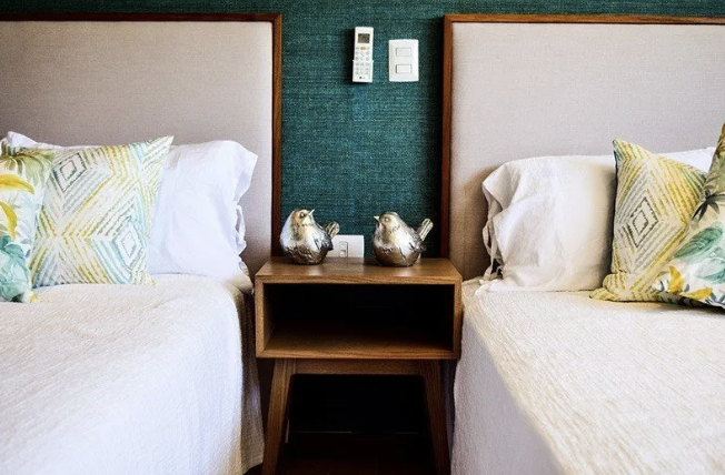 Hotel guest room with two beds, a nightstand and wall controls