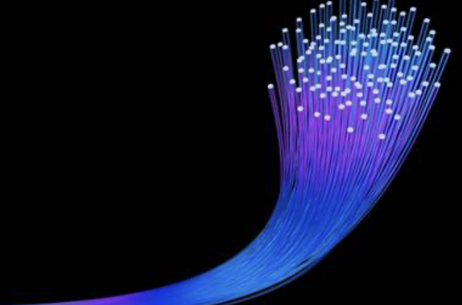 Bundle of glowing fiber optic strands against a black background