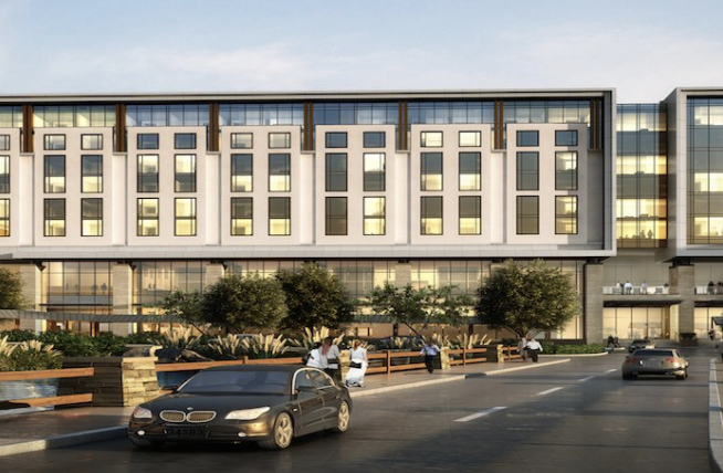 Rendering of a multi-story hotel exterior with landscaped entry drive and cars