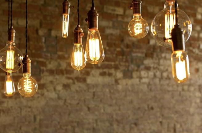 Vintage Edison light bulbs hanging in front of an exposed brick wall