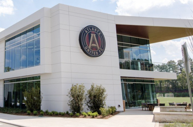 Modern white and glass building with the Atlanta United FC crest on its facade