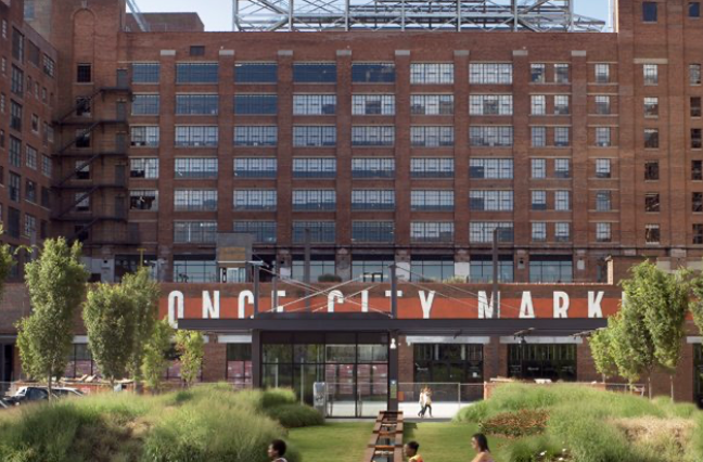 Ponce City Market's historic brick building with its large rooftop sign and green lawn