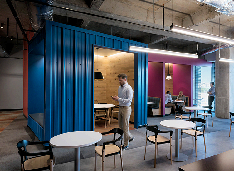 State Farm office huddle rooms built from blue shipping containers with café tables