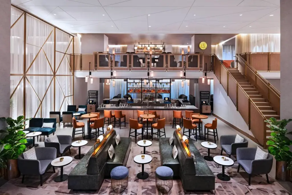 Lobbyist bar at the hotel with two-story seating, staircase and lounge chairs
