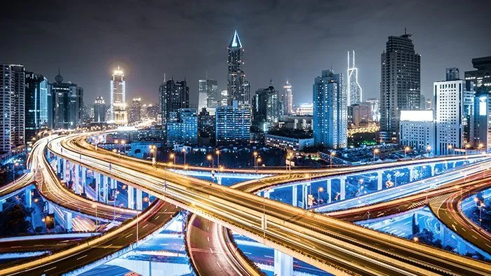 Night city skyline with illuminated multilevel highway interchange