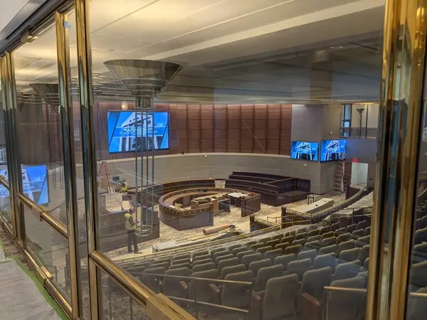 Fulton County chamber under renovation seen through glass doors, with wall-mounted displays