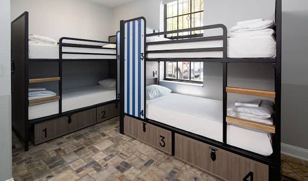 Generator hostel dorm room with numbered bunk beds and under-bed storage drawers