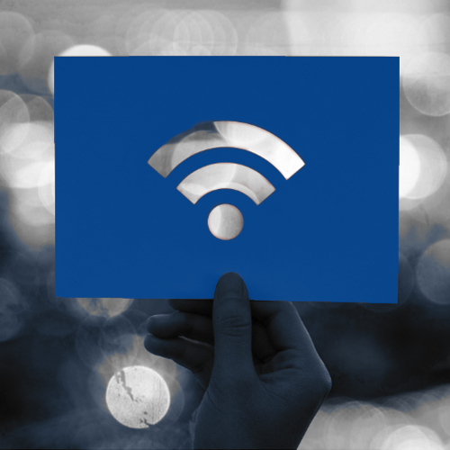 Hand holding a blue card with a Wi-Fi symbol cutout against a black-and-white background