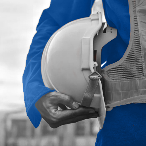 Black-and-white photo of a worker in a blue jacket holding a white hard hat