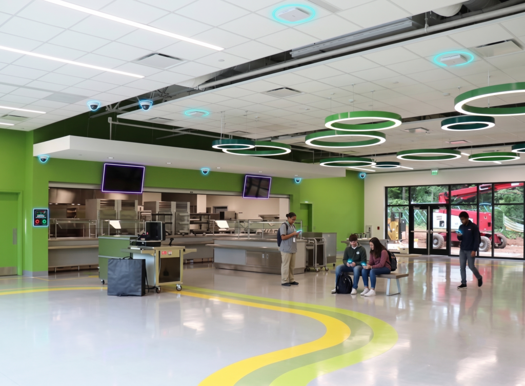 Cafeteria at Talley Street Elementary with students and overlaid Wi-Fi and camera icons