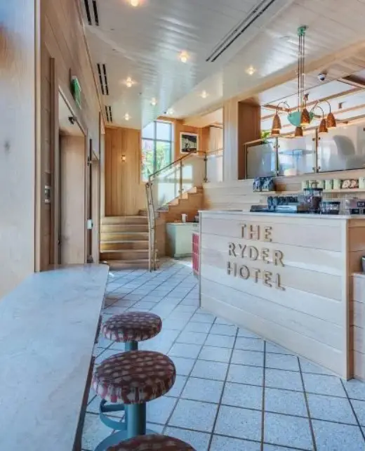 Front desk at The Ryder Hotel with wood-paneled counter reading 'The Ryder Hotel'