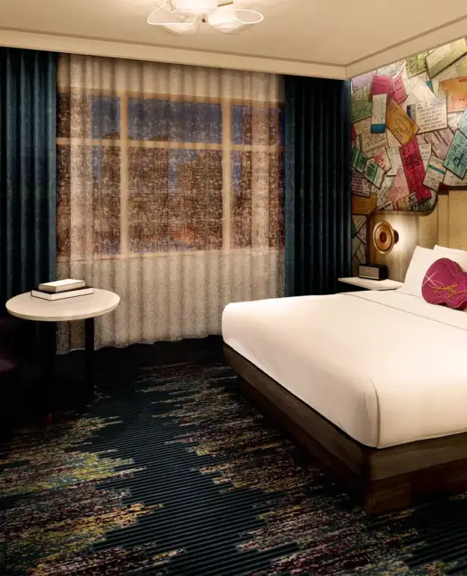 SongTeller hotel guestroom with a concert-ticket collage wall and a pink guitar pillow on the bed