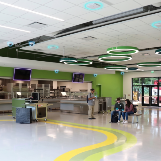 Cafeteria at Talley Street Elementary with students and overlaid Wi-Fi and camera icons